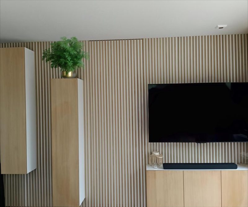 Wandmeubel van Atelier SPC met eiken latten, zwevend tv-meubel en verlichte vakken